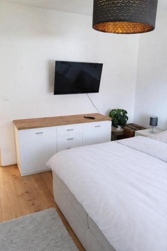 a bedroom with two beds and a flat screen tv at Das Litzldorf in Sankt Michael im Lungau