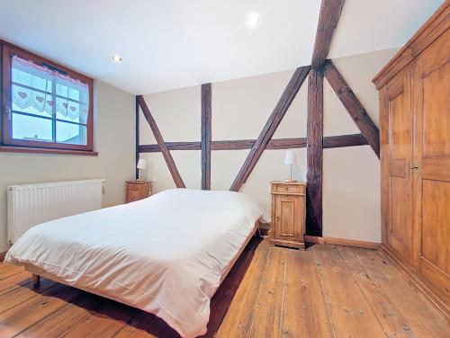 a bedroom with a white bed and wooden floors at Les Perles du Ried - Gîte 7 - 15mn Europapark - Proche Strasbourg Colmar in Boofzheim