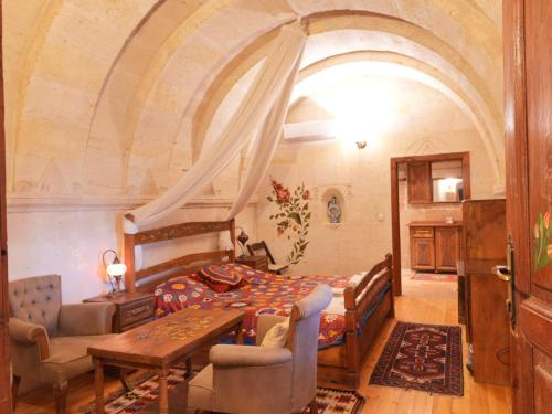 a bedroom with a bed and a table at Kismet Cave House in Göreme