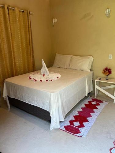 a bedroom with a bed with a red and white blanket at Bougainvillea Atins in Atins