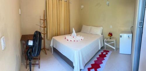 a bedroom with a bed with a cake on it at Bougainvillea Atins in Atins