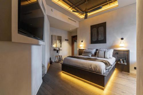 a bedroom with a bed and a flat screen tv at WABI-SABI Hôtel Lorrain - Self Check-in in Nice