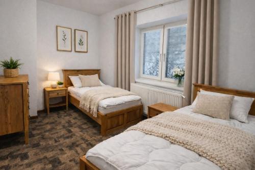 a bedroom with two beds and a window at Hangot Apartments in Repisko