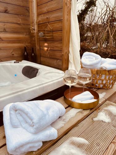 a bathroom with a tub and glasses of wine at Hyggeligt hus i Haderslev med wellness og massage in Haderslev