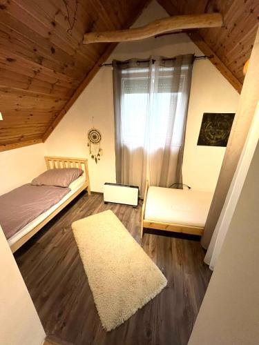 a small bedroom with a bed and a rug at Non stop apartman in Kaposvár