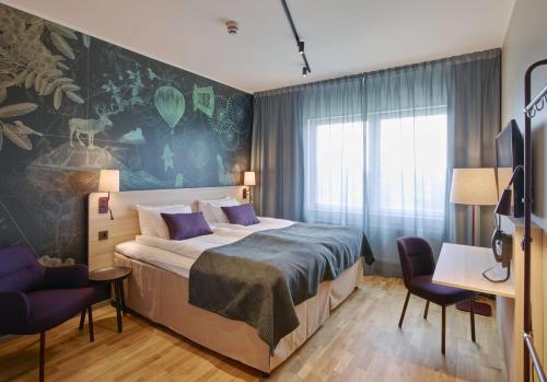 a bedroom with a large bed with purple pillows at Scandic Luleå in Luleå