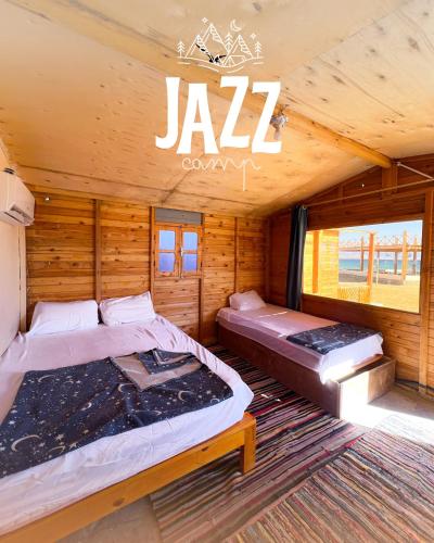 a room with two beds in a log cabin at Jazz Nuwibaa Camp in Wāsiţ