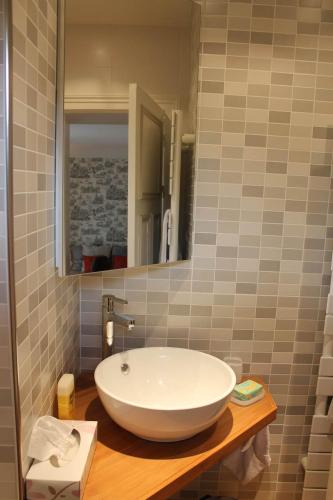 a bathroom with a large white sink on a wooden counter at Demeure de la pompe in La Queue-en-Brie