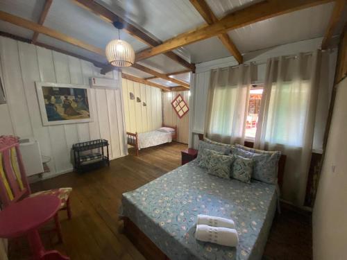 a bedroom with a bed and a couch in a room at Pousada Cantuá in Ilha do Mel
