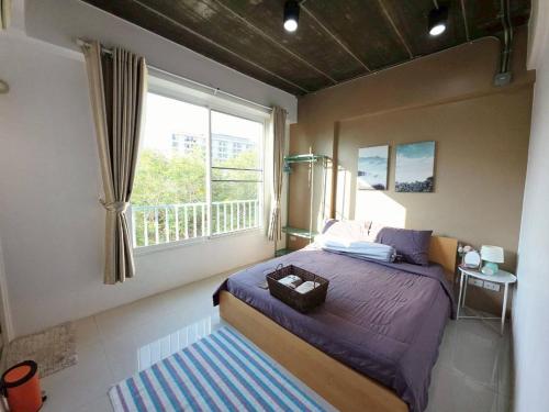 a bedroom with a bed and a large window at Boxsoon Nimman 3 # 4beds 4baths in Chiang Mai