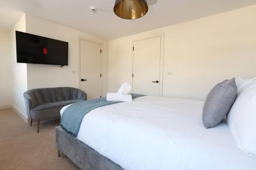 a bedroom with a large white bed and a chair at Albert Hall 1 Bed ApartHotel- Food & Bar Onsite in Swansea