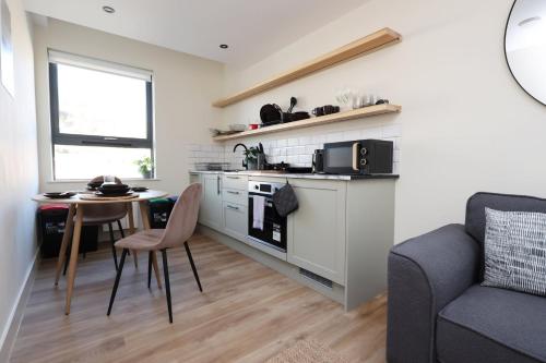 a small kitchen with a table and a couch at Albert Hall 1 Bed ApartHotel- Food & Bar Onsite in Swansea