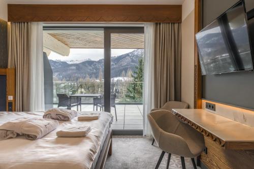 a hotel room with a bed and a large window at TatryTop Giewont House Wellness in Kościelisko
