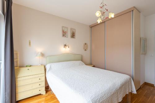 a bedroom with a white bed and a dresser at Sunny Side Wellness Resort & Spa in Budva