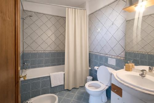 a bathroom with a toilet and a sink and a shower at The Tree House Coliving in El Médano