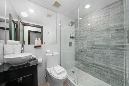 a bathroom with a toilet and a glass shower at Metropole Suites South Beach in Miami Beach