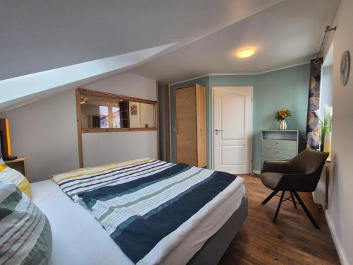 a bedroom with a large bed and a chair at # Ausblick LübEck in Lübeck