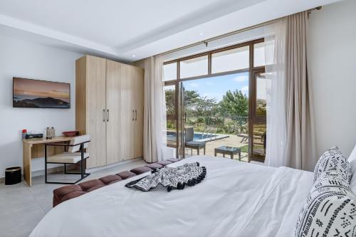 a bedroom with a bed and a desk and a window at OSOTUA Villa 18 Home Hotel Nanyuki 7 Bedrooms 14 Guests in Nanyuki