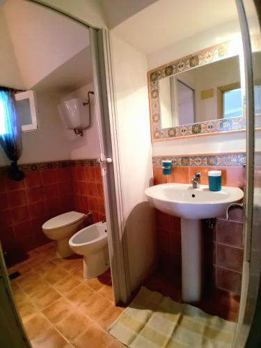 a bathroom with a sink and a toilet and a mirror at Belvedere in Pantelleria
