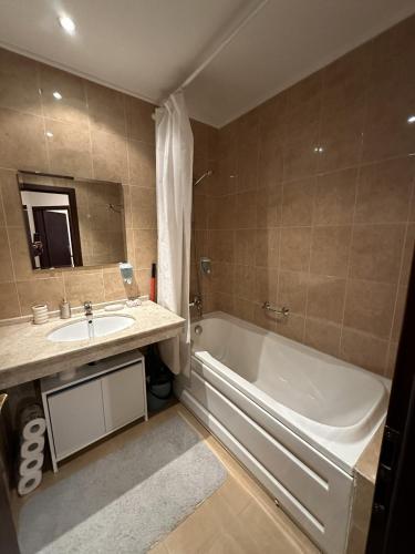 a bathroom with a tub and a sink and a bath tub at Borealis Apartment in Bansko