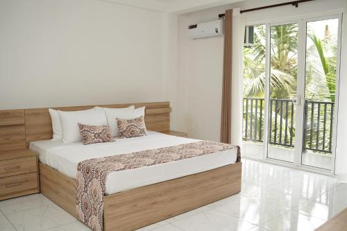 a bedroom with a bed and a large window at Meadow Breeze in Kandy
