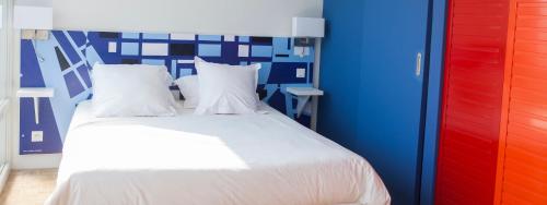 a bedroom with a bed with a blue and red wall at Escale Quai George V in Le Havre