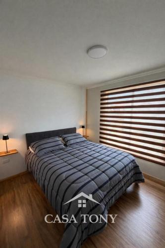 a bedroom with a bed and a large window at Casa Tony Natales in Puerto Natales