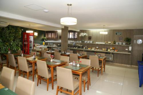 a restaurant with wooden tables and chairs and a counter at Class Hotel Guaxupé in Guaxupé