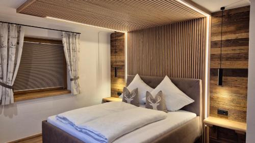 a bedroom with a large bed with a window at Chalet Auszeit - Wohlfühlzeit Naturdesign Chalet`s in Rimbach