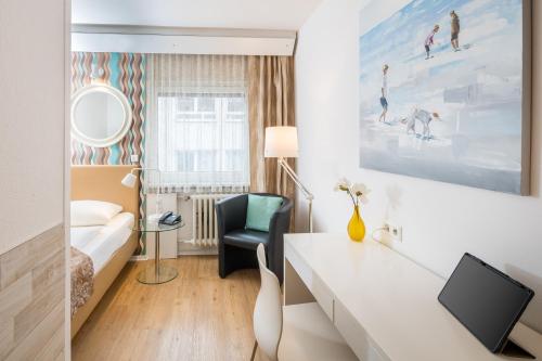 a hotel room with a bed and a desk at Hotel Erbprinzenhof in Karlsruhe