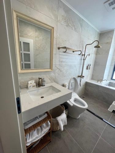 a bathroom with a sink and a toilet and a mirror at 蘇西好日子別墅 in Sanxing