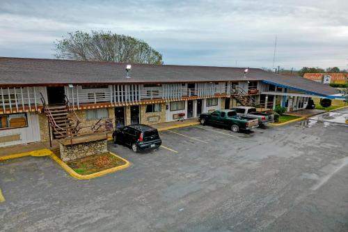 an empty parking lot in front of a motel at Cannon Inn By Capital O Gonzales Tx in Gonzales