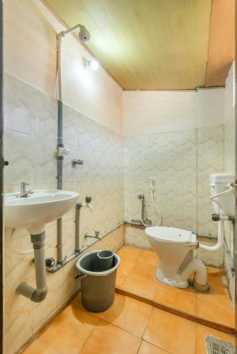 a bathroom with a sink and a toilet at Grape Rooms in Perintalmanna
