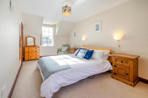 a bedroom with a large bed and a wooden dresser at 3 Bed in Kingsbarns oc-k30925 in Kingsbarns