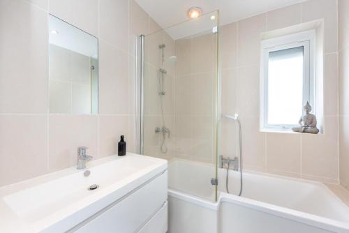 a white bathroom with a sink and a shower at 4 Bed in Saltdean oc-a32366 in Saltdean