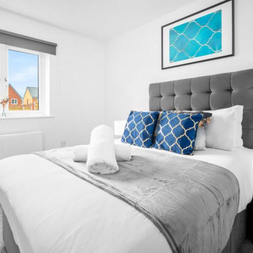 a bedroom with a large white bed with blue pillows at Modern 2 Bed Apartment - Parking - Sleeps 3 - Netflix 27AC in Sleightholme