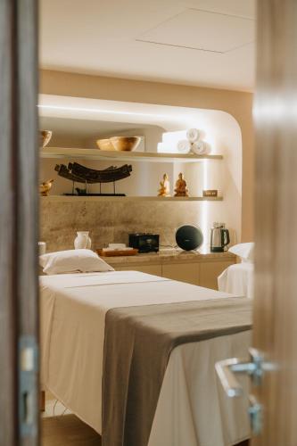 a room with two beds and a kitchen with shelves at Promenade Palladium Leblon in Rio de Janeiro
