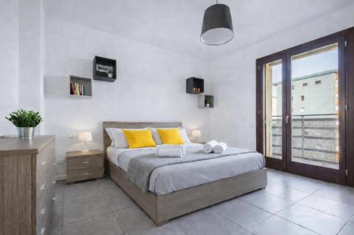 a bedroom with a bed with yellow pillows and a window at Sarca 11th Floor in Milan