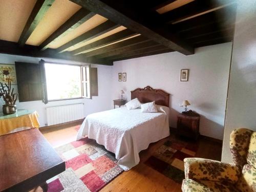 a bedroom with a white bed and a window at Casona de Gómez y Terán in Renedo