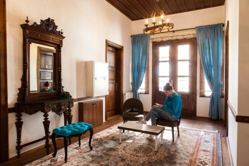 a woman sitting in a chair in a living room at Lal Hotel Bursa in Bursa