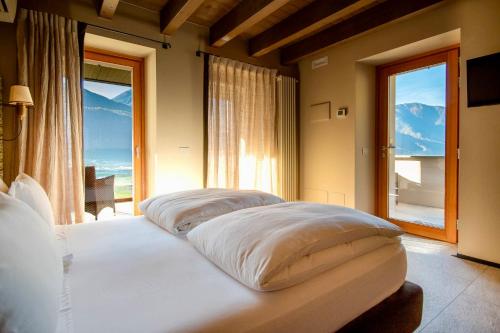 a bedroom with two beds and a large window at Ca' Barroni - Vineyard Escape in Sondrio