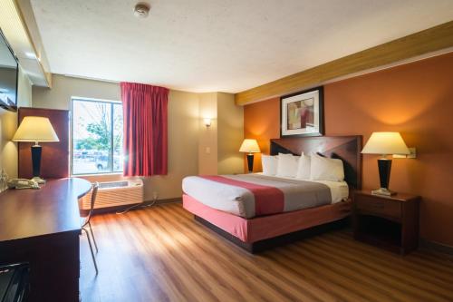 a hotel room with a bed and a desk at Motel 6-Indianapolis, IN - Airport in Indianapolis