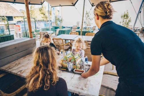 a man and a woman and a child at a table at 't Hooge Holt in Gramsbergen