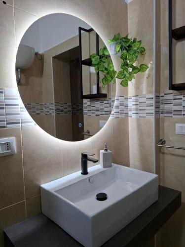 a bathroom with a white sink and a mirror at Officina dei ricordi in Casagiove