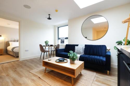 a living room with a blue couch and a table at The Central Swansea Hall 1BR Apartment in Swansea