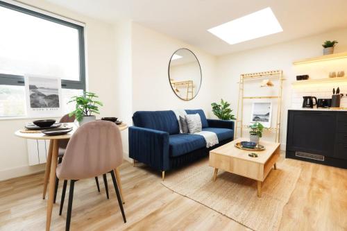 a living room with a blue couch and a table at The Central Swansea Hall 1BR Apartment in Swansea