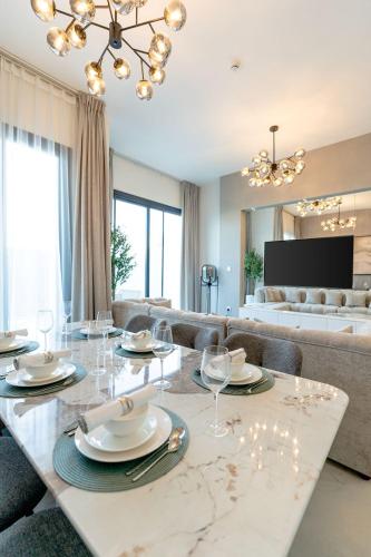 a dining room with a table and a living room at Nasma Luxury Stays - Opulent family escape in coastal community in Ras al Khaimah