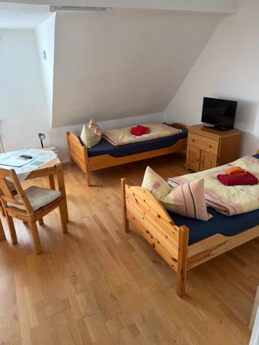 a room with two beds and a table and a table at Pension Hoffmann Remscheid in Remscheid