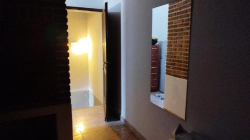 a hallway with a mirror and a brick wall at Cedro Azul in Monte Hermoso