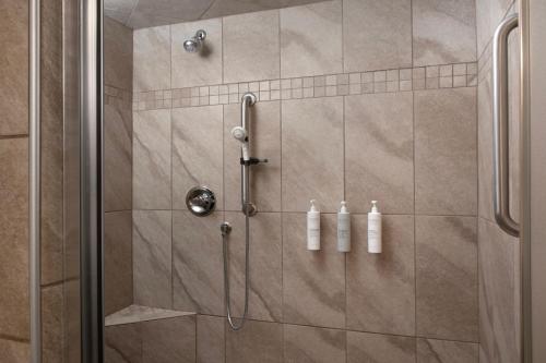 a shower with two white bottles in a bathroom at Hampton Inn Russellville in Russellville